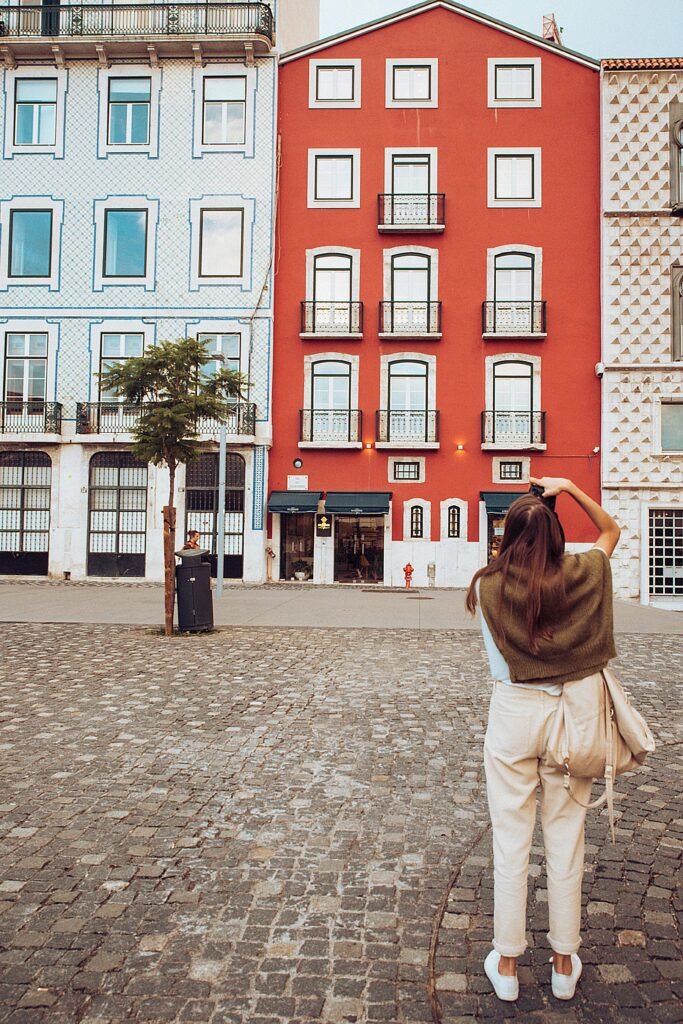 Woman captures the vibrant architecture of Lisbon, Portugal's iconic colorful buildings.